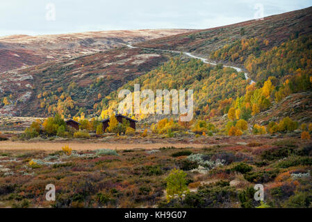 Häuser und kurvenreiche Straße in den norwegischen Bergen. Rondane, Norwegen Stockfoto