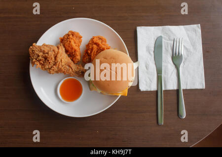Pommes frites und gebratenes Huhn in eine weiße Platte auf den Tisch wählen Sie Fokus gerückt, close-up Fast Food Stockfoto