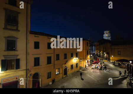 Bis spät in die Nacht Foto von Pisa Italien Übersicht der schiefe Turm von Pisa leuchtet in der Ferne über eine leere Straße mit einem Cafe Stockfoto