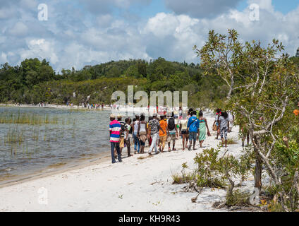 Dorfbewohner Spaziergang entlang dem Ufer zu einem zebu Opfer Zeremonie, See ampitabe, Tansania, Madagaskar, Afrika Stockfoto