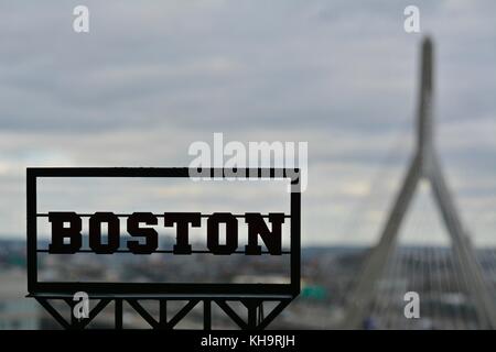 Ein "Boston" billboard Zeichen Makroaufnahme mit dem Boston Stadtbild dahinter mit der Ikonischen zakim Brücke und die Boston Skyline Stockfoto