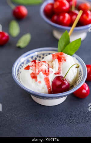 Nahaufnahme der zwei etwas geschmolzene Eis Schaufeln mit Kirschen und Beeren Marmelade Stockfoto