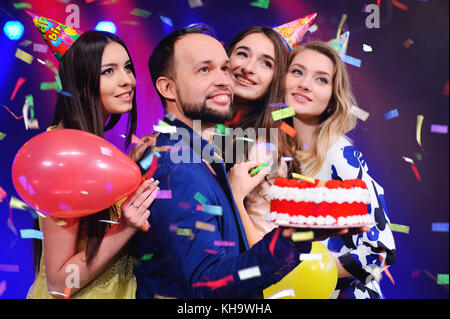 Ein Kerl und drei Mädchen freuen und die Party in der Nacht Club feiern. Stockfoto