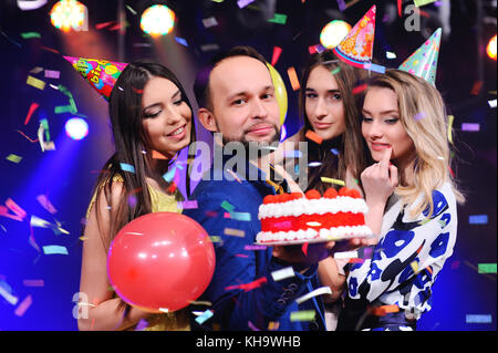 Ein Kerl und drei Mädchen freuen und die Party in der Nacht Club feiern. Stockfoto