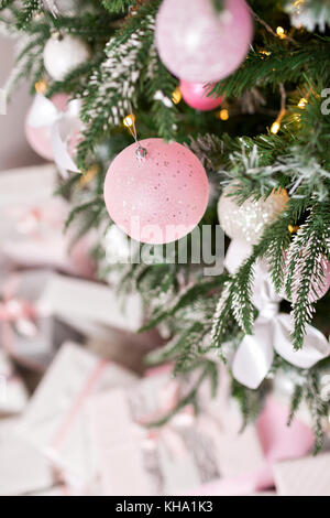 Weihnachtsbaum mit Spielzeug in Silber und rosa Farbe dekoriert. Darin sehen wir die Ballons mit der Bänder und Leuchten Leuchtende Girlande. Stockfoto
