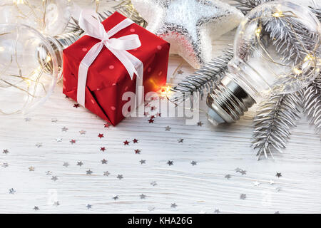 Weihnachten Fir Tree Branch, Geschenkbox und dekorativen Glühlampen auf weißem Hintergrund mit Konfetti Stockfoto