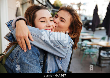 Nahaufnahme von zwei emotionale glückliche Frau Freunde Umarmen auf Stadt. Stockfoto