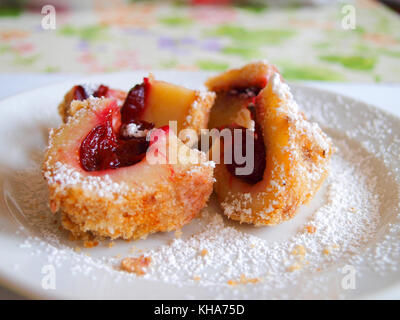 Pflaume Knödel bestreut mit Puderzucker auf einem weißen Teller. Stockfoto