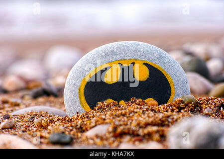 Paphos, Zypern - 22. November 2016 Kiesel mit gemalten Zeichen Batman am Strand mit Sand und Steine. closeup. Stockfoto