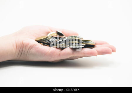 Hand mit einem Bündel os Münzen, isoliert auf Weiss. Wirtschaftliche Szenario. Stockfoto