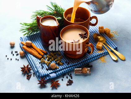 Gießen Masala Tee Chai Latte traditionelle Hot indischen Tee Zeremonie süße Milch mit Gewürzen, Kräutern Organic Infusion gesundes Getränk aus Porzellan Schale Stockfoto