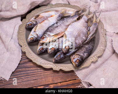 Getrocknete Fische gesalzen Ram in einer eisernen Platte auf einem braunen Holz- Hintergrund, Ansicht von oben Stockfoto