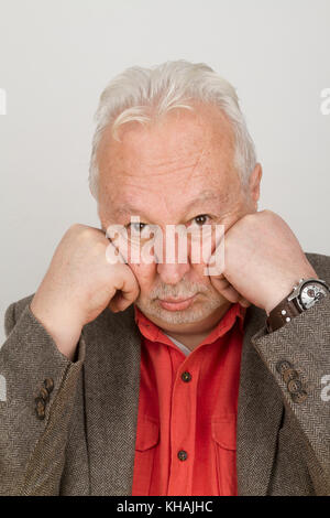 Ältere person schmollt mit seinem Gesicht in seine Hände - auf hellen Hintergrund Stockfoto