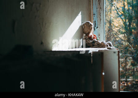 Ein Kind das stofftier Puppe ruht auf einer Schule Spind in einem verlassenen Gebäude in Pripyat, Tschernobyl Arbeiter Stadt, Ukraine Stockfoto