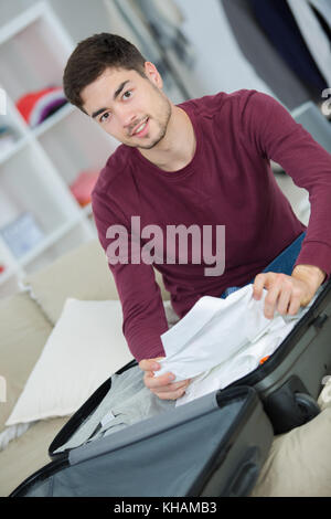 Der Mensch seine grauen Koffer im Wohnzimmer Stockfoto