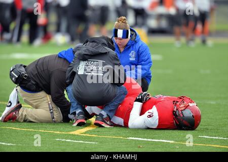 Verletzt Fußball-Spieler auf dem Feld, das die Ausbildung und das medizinische Personal behandelt. USA. Stockfoto