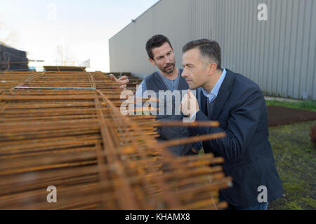 Zwei Männer, die durch Stapel von verstärkungsleisten Stockfoto