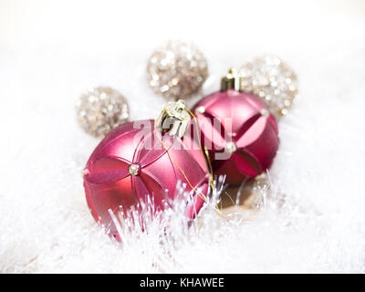 Schöne Nahaufnahme Foto von Rot, Gold und Silber Weihnachtsverzierungen Festlegung auf weiß schimmernden Girlande machen einen tollen Urlaub Hintergrundbild. Stockfoto
