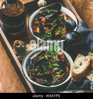 Belgische Gekochte Miesmuscheln in hellen Bier in der Flasche. Stockfoto