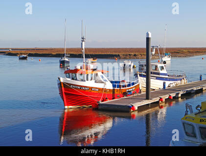 Ein Blick auf kommerzielle Boote, die mit einem Ponton im Hafen von North Norfolk in Wells-next-the-Sea, Norfolk, England, Vereinigtes Königreich befestigt sind. Stockfoto