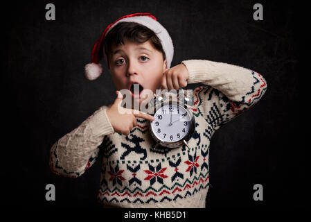 Überrascht Kind in Silvester auf schwarzem Hintergrund Stockfoto