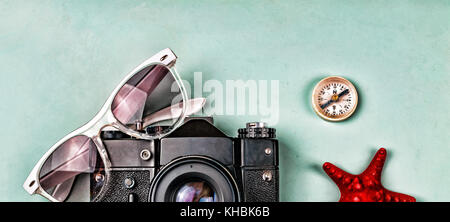 Alte Kamera, Sonnenbrille, alten Kompass und Seesterne auf einem blauen Hintergrund. Das Konzept: Reise, Urlaub, aktive Freizeitgestaltung, Seereisen. Stockfoto