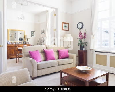 Eine frische, leichte, traditionelle und zugleich moderne Wohnzimmer mit Blick in den Essbereich. mit Sofa, Couchtisch und standard Lampe ausgestattet. Stockfoto