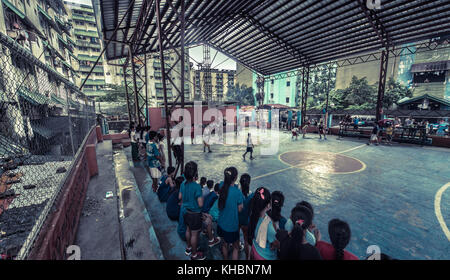 Armen jugendlichen Basketball spielen im Slumgebiet. Durch karge Betonsteine umgeben. Stockfoto