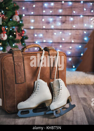 Frauen skates neben einem alten Leder Koffer und einen Weihnachtsbaum. Weihnachtsschmuck Stockfoto