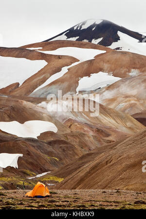 Ein Zelt auf einem schneebedeckten Rhyolith-Berg, Hochtemperatur-Bereich Hveradalir, Kerlingarfjöll, Insel Stockfoto