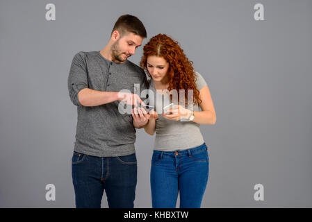 Ein hübscher junger Mann sein Smartphone mit seiner schönen Freundin Stockfoto