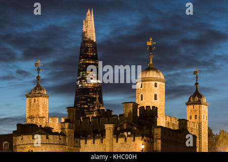 London's alte und neue Architektur mit dem Shard Wolkenkratzer hoch aufragenden hinter der beleuchtete Turm von London in der Abenddämmerung. Stockfoto