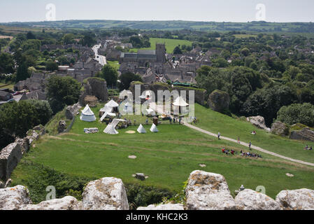 Blick von der alten Bergfried von Corfe Castle auf der Suche nach unten über die Tented Camp besetzt von National Trust Personal in Richtung des Dorfes. Stockfoto