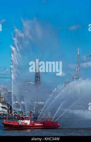 Die Katharinenkirche in Hamburg zwischen den Wasserfontänen eines Feuerwehrschiffs beim Hafengeburtstag Stockfoto