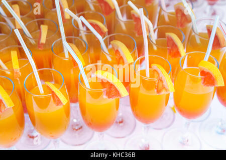 Orangensaft Cocktail in einer Flöte Gläser und Scheibe frische Orange mit Hinweisen auf weißer Tisch, geschlossenes Bild. Stockfoto