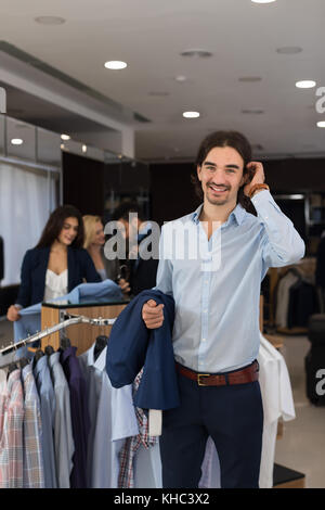 Stattliche business Mann Anzug holding Jacke in den Händen der modernen Herrenmode shop Verschleiß Stockfoto