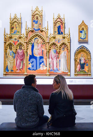 Florenz, Italien - 31. Oktober 2017: Paar genießt eine Arbeit der mittelalterlichen religiösen Kunst in der berühmten Galleria dell'Accademia Stockfoto