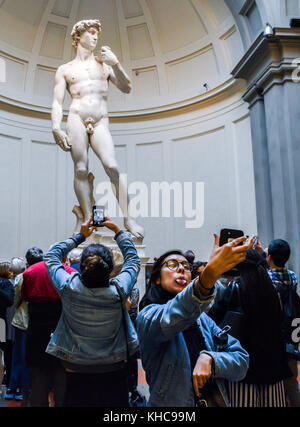 Eine junge Frau nimmt einen Abstecher vor Michelangelos David in der Galleria dell'Accademia in Florenz Stockfoto