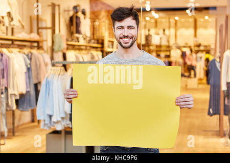 Junge Mann hält Gelb leer Namensschild als Werbung für Mode Stockfoto