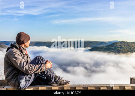 Seite Profil des Menschen auf Geländer von Bergen und schwebenden Nebel Wolken am Morgen in Grandview übersehen, West Virginia sitzen Stockfoto