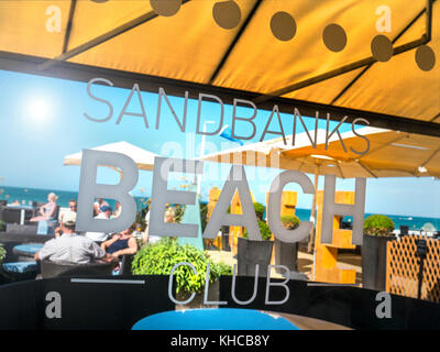 UK STRAND GETRÄNKE TERRASSE IM FREIEN Sandbanks Beach Club Terrasse mit Menschen genießen einen Aufenthalt Drink und Snack auf einem sonnigen Tag auf der berühmten luxuriösen Sandbanks-Halbinsel Poole Dorset UK Stockfoto