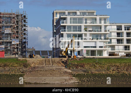 Bremen, Deutschland - 6. November 2017 - Baustelle mit Bagger, Gerüst und Rampe, die zum Wasser führt, neben bereits fertiggestellten Luxus Stockfoto