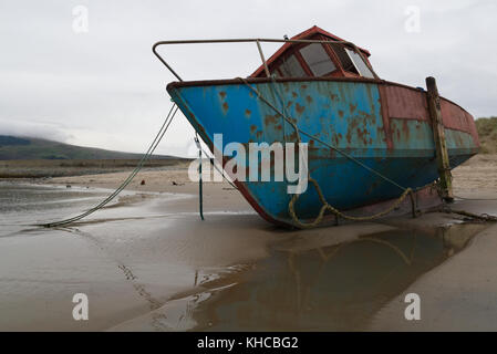Rostigen blauen und roten Fischerboot auf Sandstrand in Pwllheli Mündung, abermaw, Wales Stockfoto