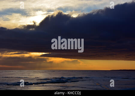 Sonnenuntergang über gefrorene Meer. stürmische Wolken, Abends Stockfoto