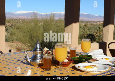 Typische marokkanische Frühstück mit Blick auf den Atlas Gebirge im Hintergrund, auf dem Dach eines Kasbah in Skoura Stockfoto