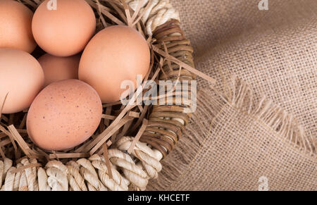 Braune Eier in einen Korb und auf einer Leinwand Tuch Stockfoto