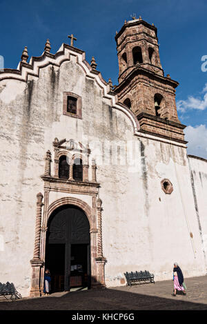 Eine ältere Frau geht an der Fassade des Tempels der Einsamkeit und des Alten Indianischen Krankenhauses in Tzintzuntzan, Michoacan, Mexiko vorbei. Stockfoto