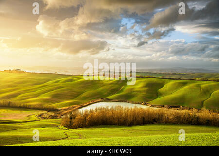 Toskana misty Panorama, See, Hügel, Felder, Wiese und Bäume bei Sonnenuntergang. Italien, Europa Stockfoto