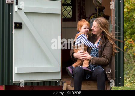 Frau und Mann Toddlersohn im Eingang des traditionellen Gypsy Caravan sitzen Stockfoto