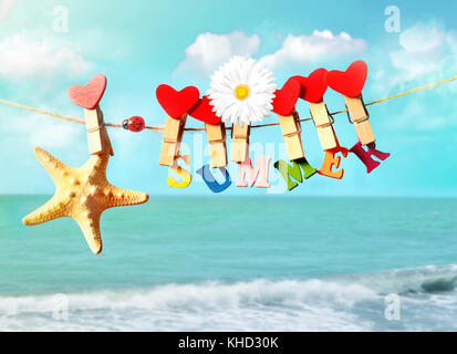 Seesterne mit Buchstaben und Blume hängend von Wäscheklammern auf Sommer Strand Stockfoto